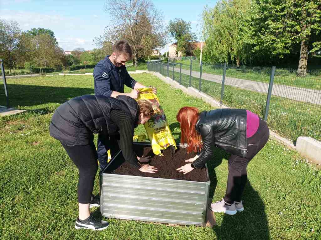 Dan-planeta-Zemlje-IV - Roditelji uz ogradu izrađuju povišeni vrt u koji sipaju zemlju.