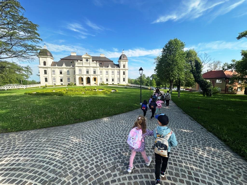 Izlet-skupine-Tockice-II - Djeca  hodaju prema dvorcu popločeno stazom kroz lijepo uređen park.