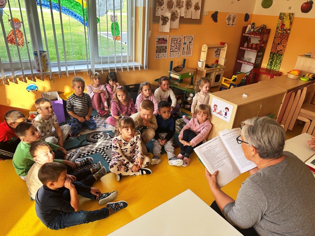 Medunarodni-dan-starijih-osoba Djeca sjede i slušaju priču 
